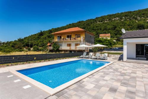 a swimming pool in front of a house at Kuća Grab in Grab