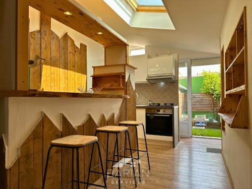 a kitchen with a counter and stools in it at 7min de la plage - Maison typique - Cour privative in Fouras