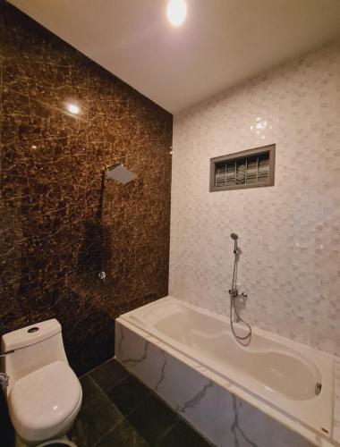 a bathroom with a toilet and a bath tub at Oemah Sawah99 in Batu