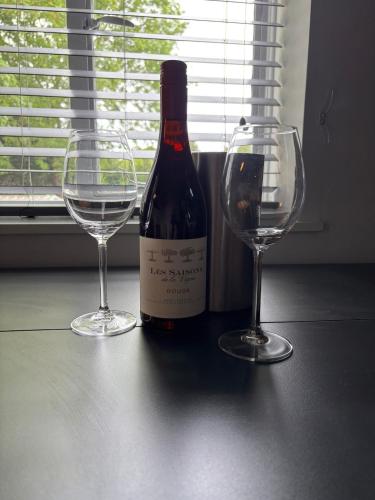a bottle of wine and two wine glasses on a table at Boutique 2 bedroom apartment in Mersham