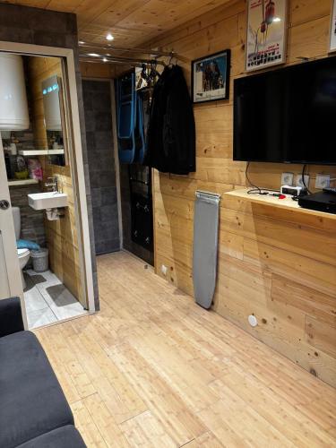 un salon avec une télévision à écran plat sur un mur dans l'établissement SebRem, à Megève