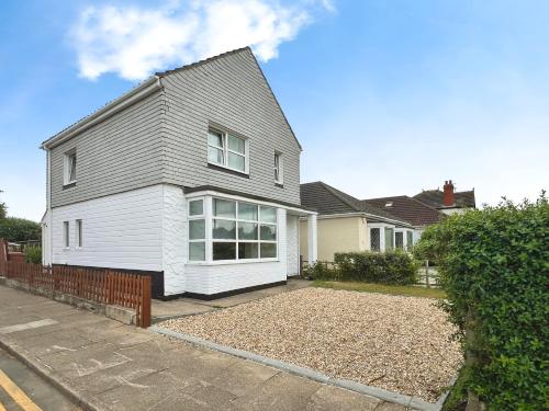 a white house with a gray roof at Cleethorpes Modern Home in Old Clee