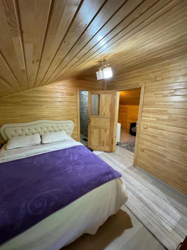 a bedroom with a large bed in a room with wooden walls at Mavera Suite in Uzungöl