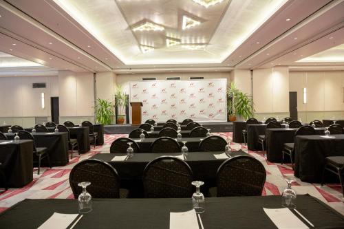 a conference room with tables and chairs and a screen at Waterfront Insular Hotel Davao in Davao City