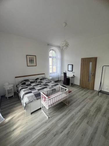 a bedroom with a bed and a wooden floor at Apartmány LISTOPAD 17 in Děčín