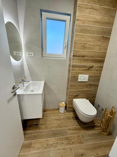 a bathroom with a sink and a toilet and a window at Guest House Stipe in Brela