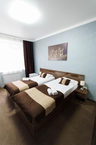 two beds in a room with blue walls at Premier Inn Astana in Astana
