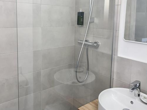 a bathroom with a shower and a sink at Aka Lodge Lyon Eurexpo Arena Stadium in Meyzieu