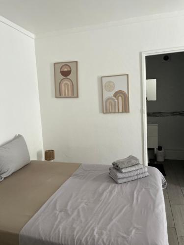 une chambre avec un lit et deux tableaux au mur dans l'établissement Studio cosy au cœur du centre ville idéal pour visiter Marseille, à Marseille