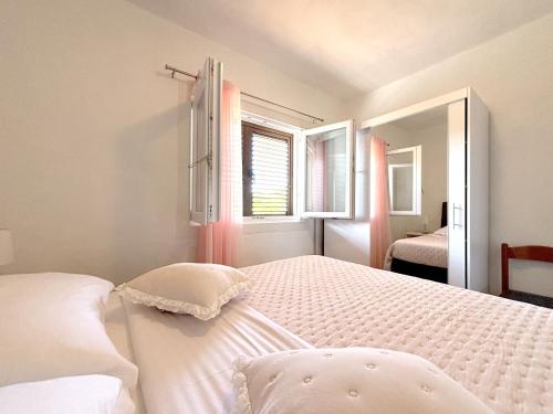een slaapkamer met een wit bed en een raam bij Apartments Venilia in Lukoran
