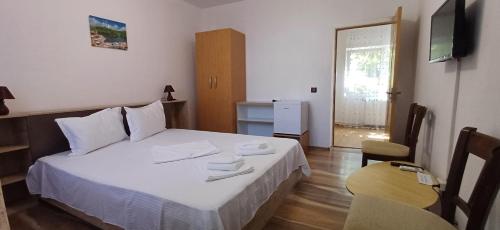 a bedroom with a bed and a table and a television at Casa Ella in Tuzla