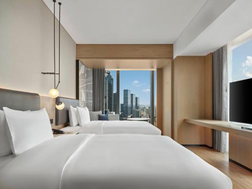 two beds in a hotel room with a view at AC Hotel Suzhou Industrial Park in Suzhou
