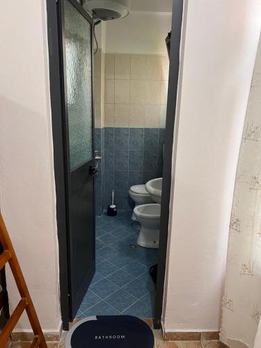 a bathroom with two toilets and a door open at Michelle's Apartments in Polisi i Vogël