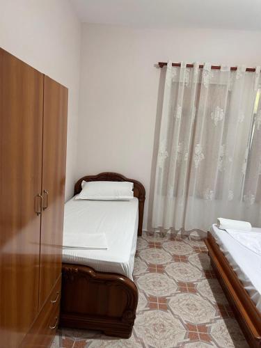 a bedroom with two twin beds and a window at Michelle's Apartments in Polisi i Vogël