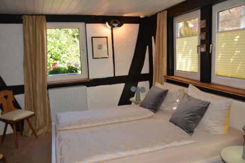 een slaapkamer met een wit bed en 2 ramen bij Ferienhaus 1534 in Neustadt an der Weinstraße