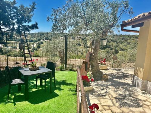 a table and chairs in a yard with a tree at "The Cottage"with sea view, parking & wifi in Avola