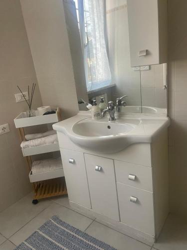 a white bathroom with a sink and a mirror at Ciak si dorme in Marina di Massa