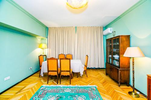 una stanza con un tavolo e delle sedie in una stanza di PRAMİDA Apartment a Baku