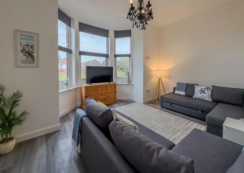 a living room with a couch and a flat screen tv at Euston Road - Beach Apartment 8 in Great Yarmouth
