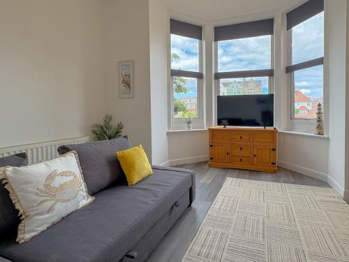 a living room with a couch and a flat screen tv at Euston Road - Beach Apartment 8 in Great Yarmouth