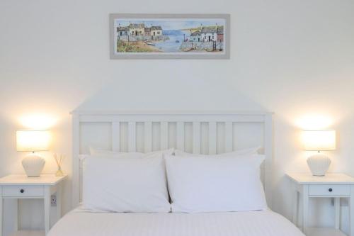 a bedroom with a white bed with two white night stands at Euston Road - Beach Apartment 8 in Great Yarmouth