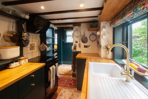 eine Küche mit Spüle und Herd in der Unterkunft Black Tile Cottage in Lewes