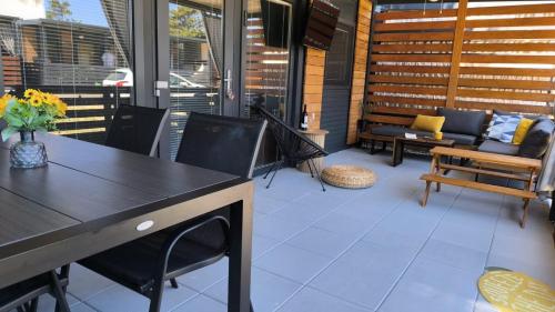 patio z kanapą, stołem i krzesłami w obiekcie Mobile home - Bokun mora w mieście Privlaka