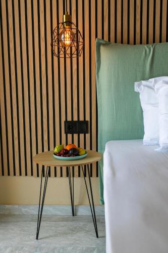 a plate of fruit on a table next to a bed at Hotel Agios Thomas in Ligia