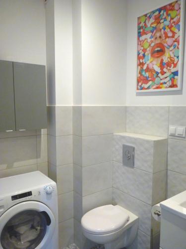 a bathroom with a toilet and a washing machine at Apartament Glatz - na Letniej, Kłodzko, winda, garaż podziemny, balkon z widokiem na góry in Kłodzko