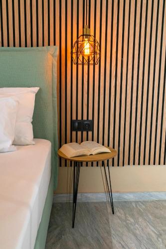 a table with a book on it next to a bed at Hotel Agios Thomas in Ligia