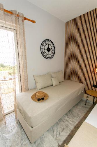 a bedroom with a bed with a clock on the wall at Hotel Agios Thomas in Ligia