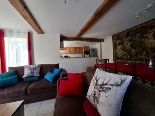 - un salon avec un canapé marron et des oreillers colorés dans l'établissement Logis du Château de Brecy, à Saint-Jean-des-Essartiers