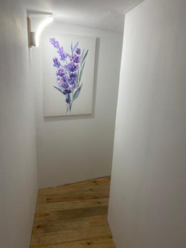 a painting of purple flowers on a white wall at Chambres d’hôtes La Voûte in Volonne