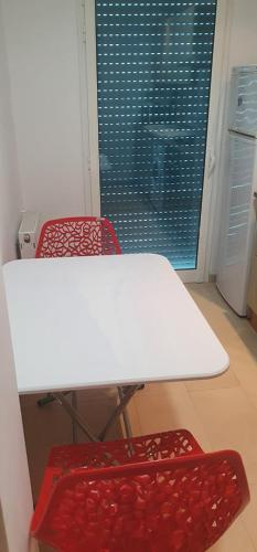 a white table and two red chairs in a room at Superb & Modern apartment at Berges Lac 2 close to Tunisia Mall in Tunis