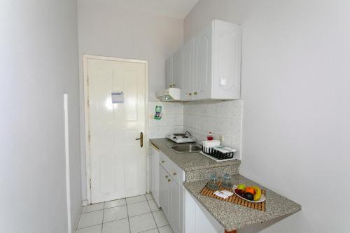 a small kitchen with a sink and a counter top at Hotel Agios Thomas in Ligia