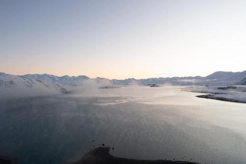 a body of water with mountains in the background at Lake Lodge Tekapo in Lake Tekapo