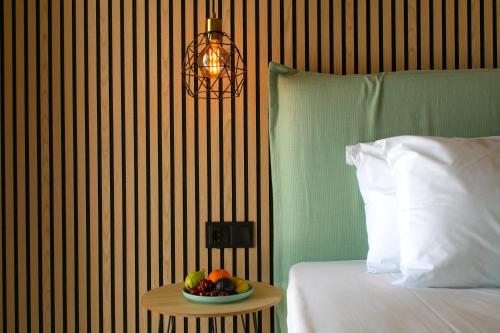 a bowl of fruit on a table next to a bed at Hotel Agios Thomas in Ligia
