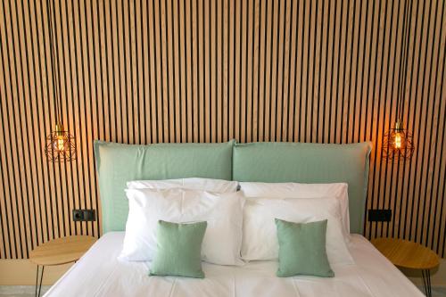 a bedroom with a bed with four pillows at Hotel Agios Thomas in Ligia
