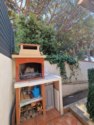 a wood fired oven sitting on a patio at Apartamento Riells in L'Escala