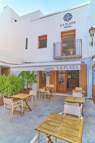 a group of tables and chairs in front of a building at La Plaza Hostal in Peñíscola
