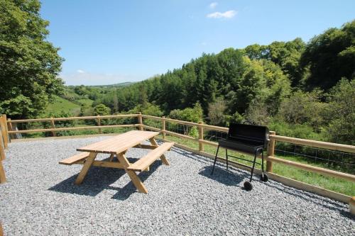 a picnic table and a piano next to a fence at Stunning location in the centre of Exmoor in Exford