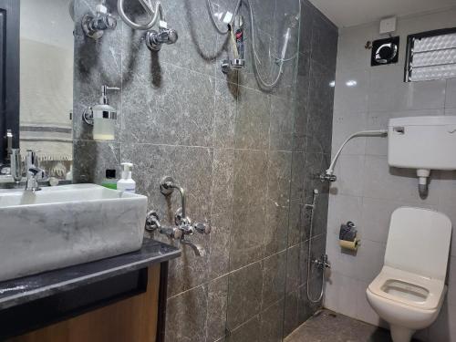 a bathroom with a shower and a sink and a toilet at Bombay High Retreat in Parhūr