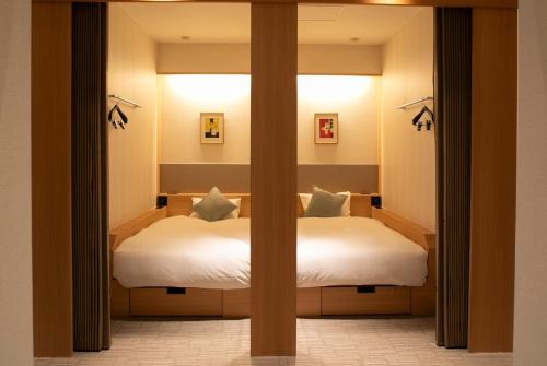 a bedroom with a large bed with a window at HOTEL LADIES PLAZA YOKOTE -female only- in Yokote