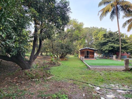 a park with a cabin and a palm tree at Bombay High Retreat in Parhūr