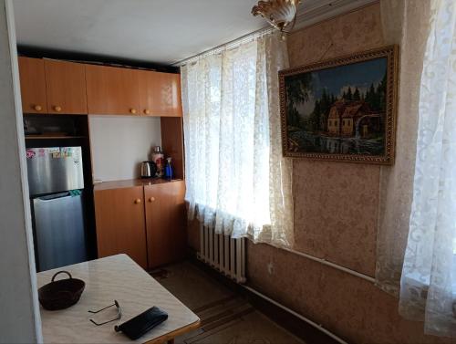 a kitchen with a table and a window at Квартира-аппартамент, 2 этаж in Chilanzar