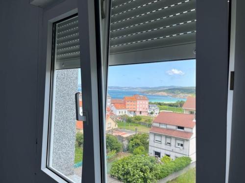 a window with a view of a city at Apartamentos Vive Laxe in Laxe