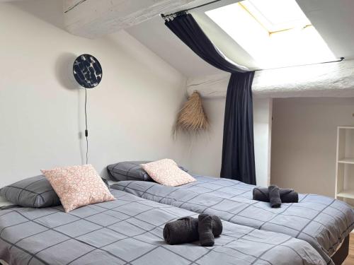 two twin beds in a room with a skylight at Valras'Loc L Escapade Serignanaise in Sérignan