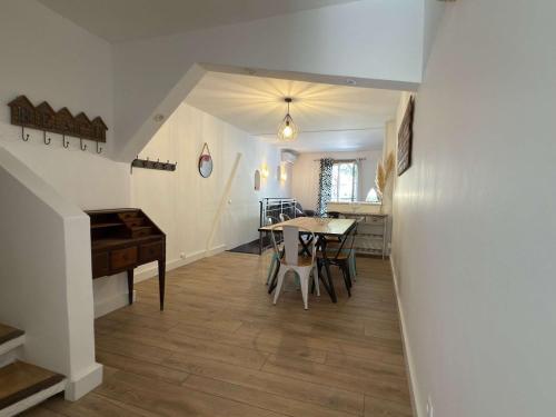 a dining room with a table and a piano at Valras'Loc L Escapade Serignanaise in Sérignan