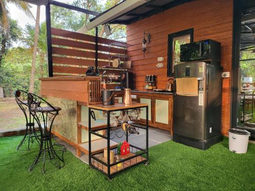 a kitchen with a counter and a refrigerator and grass at Bombay High Retreat in Parhūr