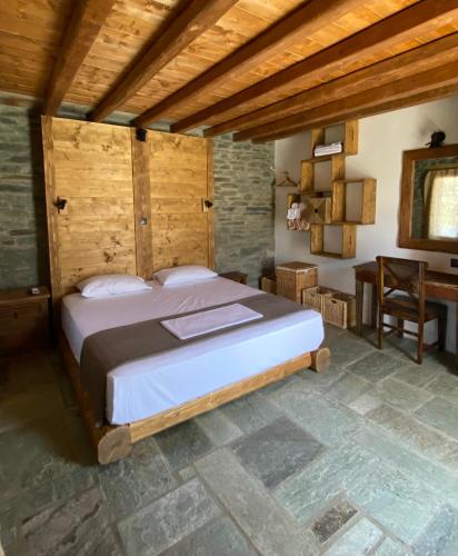 a bedroom with a large bed and a desk at Sifnos Roots in Exámbela